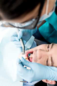 Top view of male patient examining by dentist