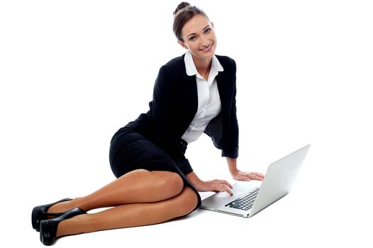Young female manager operating laptop on the floor