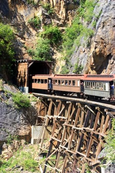 Train entering a tunnel through old bridge