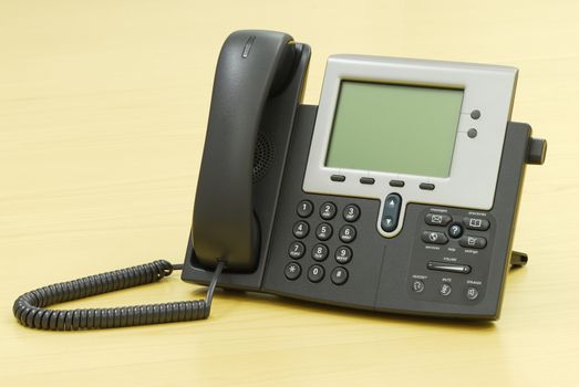 Digital VoIP phone on table.