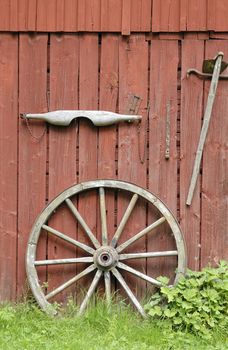 Old wheel on barn wall.