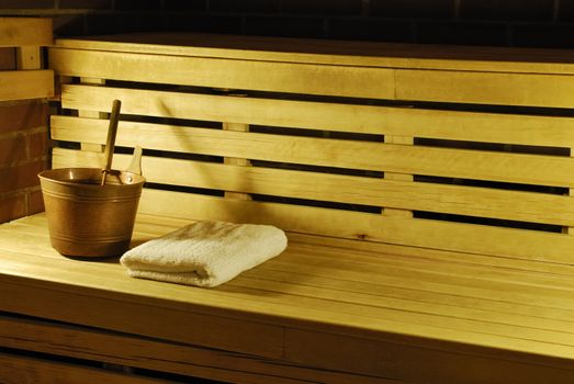 Close-up shot of inside of sauna showing bench, towels and pail.