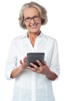 Happy senior woman operating digital tablet 