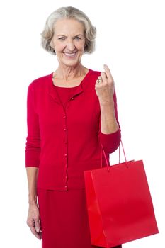 Senior woman posing with red shopping bag