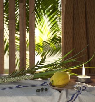 Symbols of the Jewish holiday Sukkot with palm leaves and candle