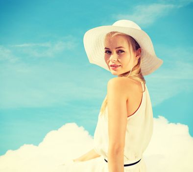 fashion and lifestyle concept - beautiful woman in hat enjoying summer outdoors
