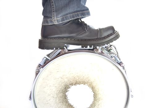 Drums conceptual image. Leg standing on overturned snare.