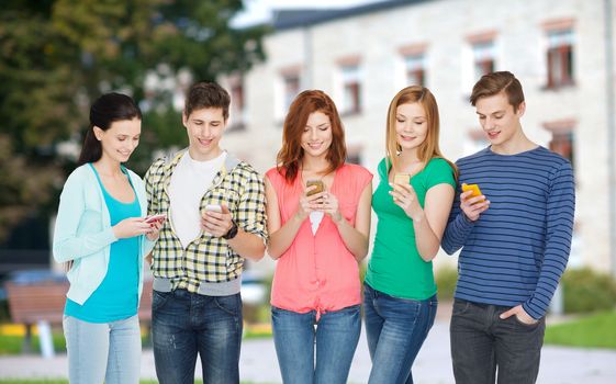 education and modern technology concept - smiling students with smartphones