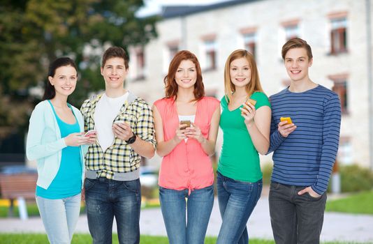 education and modern technology concept - smiling students with smartphones