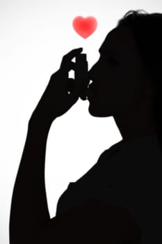 Asthmatic brunette using her inhaler  against white background with vignette