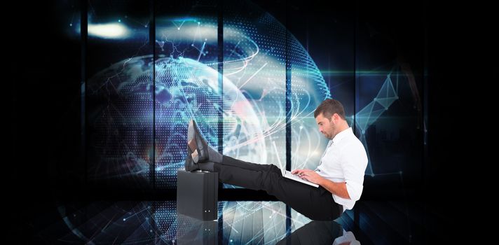 Businessman with feet up on briefcase against global technology background in blue