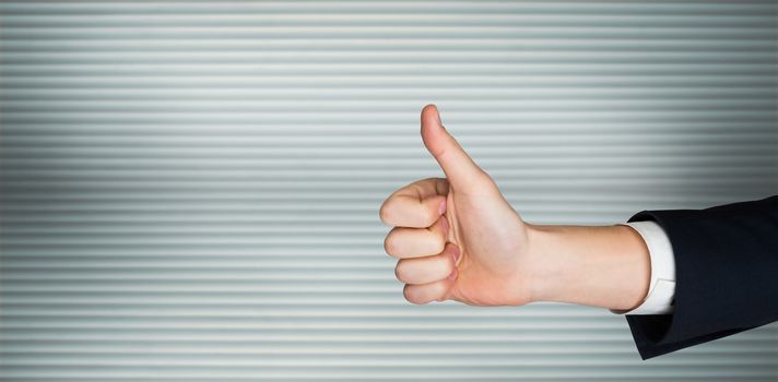 Hand showing thumbs up against grey shutters