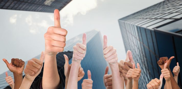 Hands showing thumbs up against skyscraper