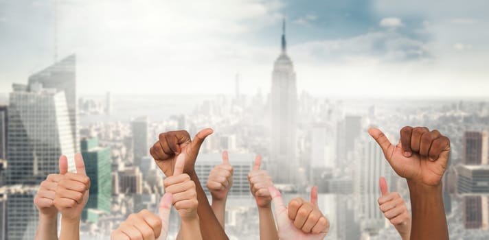 Hands giving thumbs up  against room with large window looking on city