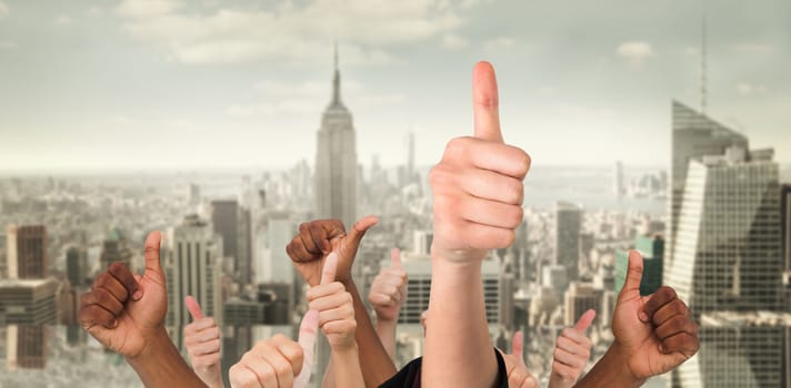 Hands showing thumbs up against room with large window looking on city