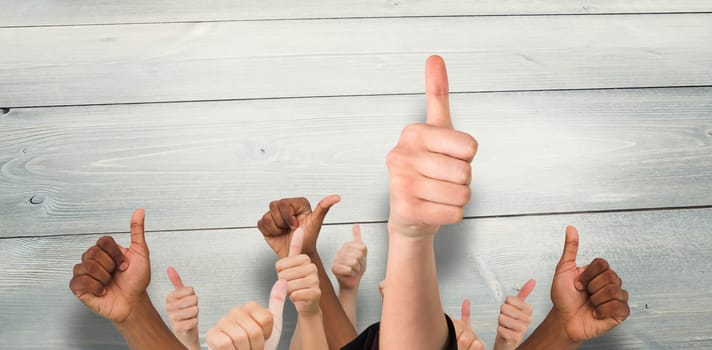 Hands showing thumbs up against bleached wooden planks background