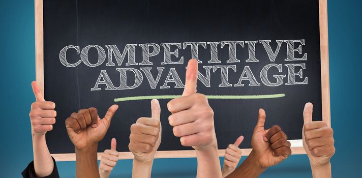 Hands showing thumbs up against competitive advantage written on a chalkboard