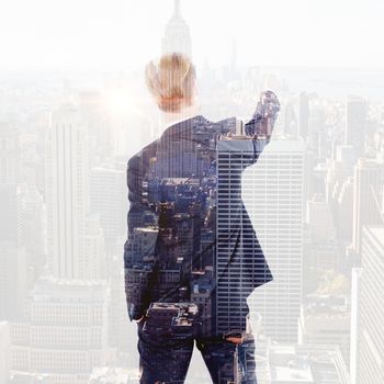 Rear view businessman writing with chalk against new york skyline