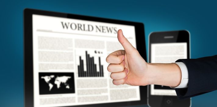 Hand showing thumbs up against digital tablet and smartphone showing news