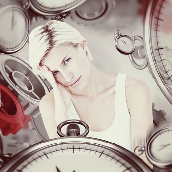 Depressed blonde woman with hand on temple  against grey vignette