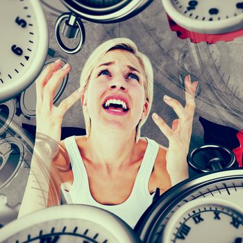 Upset woman yelling with hands up  against grey background