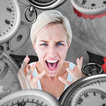 Upset woman yelling with hands up  against grey background