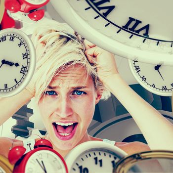 Stressed woman screaming and holding her head  against grey vignette