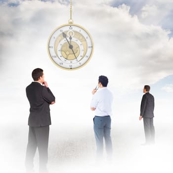 Handsome businessman looking against sky 