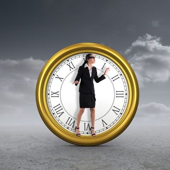 Blindfolded businesswoman with hands out against cloudy sky background