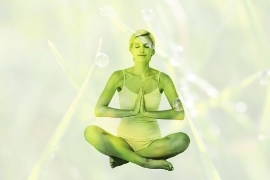 Fit woman doing yoga against dew on the grass