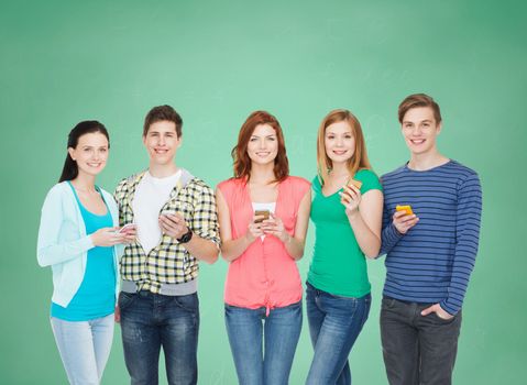 education and modern technology concept - smiling students with smartphones