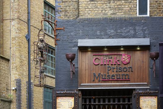 LONDON, UK - JUNE 23: Entrance to The Clink prison museum, which exhibits medieval torture tools, with replica of skeleton in cage. June 23, 2015 in London.