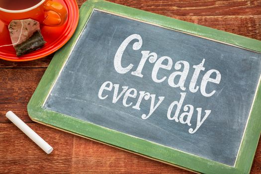 Create every day motivational reminder - motivational text on a slate blackboard with chalk and cup of tea