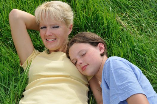 Mother and daughter making a nap on the grass