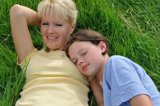 Mother and daughter making a nap on the grass