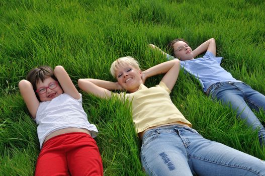Mother and daughters making a nap on the grass