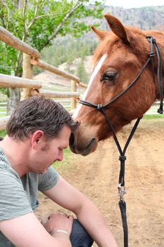 Young rancher and his trusting colt on ranch