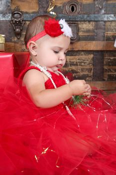 Brunette christmas baby wearing a red dress