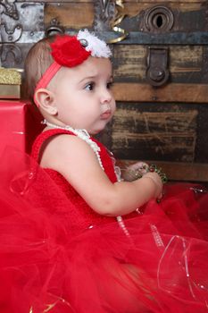 Brunette christmas baby wearing a red dress