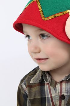 Young boy wearing a christmas elf hat