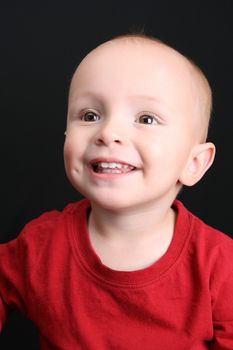 Baby boy against a black background wearing red