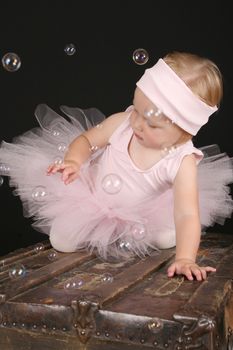 Blond girl wearing a ballet tutu playing with bubbles