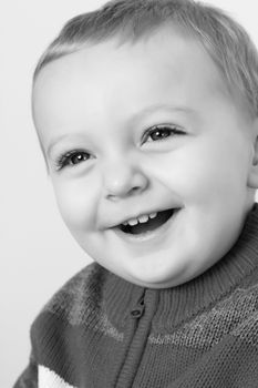 Blonde baby boy against a light background