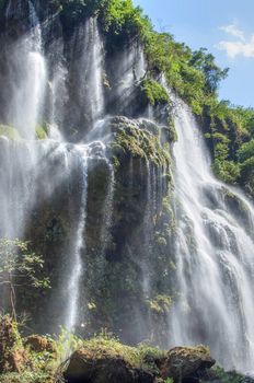 Bright sunlight shining on gorgeous tropical Cascada del Aguacero waterall in Chiapas, Mexico