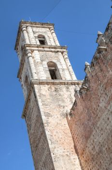 Tall stone tower of historical Cathedral of San Gervacio in Valladolid, Mexico on sunny day with blue sky background