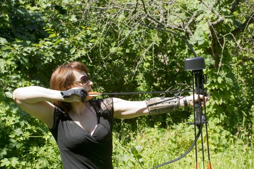 Woman shoots a bow. Sports - Archery.