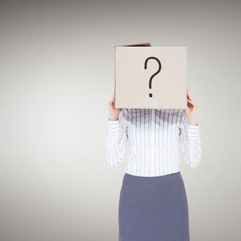 Businesswoman with box over head against grey vignette