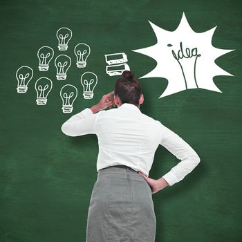 Businesswoman scratching her head against green chalkboard