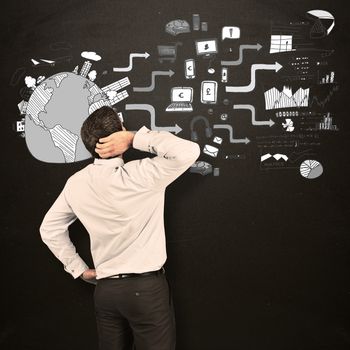 Thinking businessman scratching head against blackboard