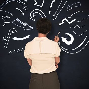 Businesswoman standing against blackboard